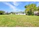 Well-maintained single-story home showcasing lush green lawn, mature tree and landscaping at 769 Crestview Nw Cir, Port Charlotte, FL 33948
