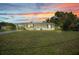 Charming single-story home featuring a well-maintained lawn and inviting curb appeal at sunset at 769 Crestview Nw Cir, Port Charlotte, FL 33948
