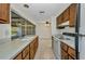 View of kitchen with wood cabinets, laminate countertops, and pass-through to the lanai at 769 Crestview Nw Cir, Port Charlotte, FL 33948