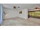 Living room with neutral carpet, fan, and a view into the sun room at 769 Crestview Nw Cir, Port Charlotte, FL 33948