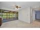 View of living room with ceiling fan, closet, and sliding glass doors to the sunroom at 769 Crestview Nw Cir, Port Charlotte, FL 33948