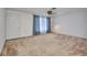 An empty living room with neutral carpet, a ceiling fan, and a front door visible on the left at 769 Crestview Nw Cir, Port Charlotte, FL 33948