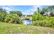 Scenic waterfront view showcasing a private dock and lush landscaping at 769 Crestview Nw Cir, Port Charlotte, FL 33948