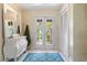 Bright foyer with tile flooring, a decorative chest of drawers, and charming double doors at 825 Via Tunis, Punta Gorda, FL 33950