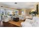 Bright living room with white furniture, wood floors, and access to a screened-in patio for indoor/outdoor living at 825 Via Tunis, Punta Gorda, FL 33950