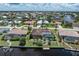 Rear exterior shot of a waterfront property with a screened-in pool, private dock, and beautiful landscaping at 825 Via Tunis, Punta Gorda, FL 33950