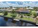 Waterfront property featuring a screened-in patio, a private dock, and lush greenery along the canal at 825 Via Tunis, Punta Gorda, FL 33950