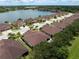 Community aerial view featuring homes, a tranquil lake, and tree-lined streets at 8814 Tuscany Isles Dr, Punta Gorda, FL 33950