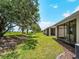 Scenic backyard view with lush green lawn and screened-in lanai, perfect for outdoor relaxation at 8814 Tuscany Isles Dr, Punta Gorda, FL 33950