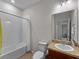 Well-lit bathroom featuring a single vanity, a mirror, a toilet, and a shower-tub combo with a white shower curtain at 8814 Tuscany Isles Dr, Punta Gorda, FL 33950