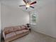 Bright bedroom with a ceiling fan, a window with blinds, neutral walls, and a cozy couch, perfect for relaxation at 8814 Tuscany Isles Dr, Punta Gorda, FL 33950