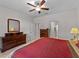 Comfortable bedroom with plenty of dresser storage, ceiling fan, and access to the bathroom at 8814 Tuscany Isles Dr, Punta Gorda, FL 33950