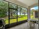Screened-in lanai with a beautiful view of lush greenery and a small patio set, offering a relaxing outdoor space at 8814 Tuscany Isles Dr, Punta Gorda, FL 33950