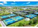 Aerial view shows a community with tennis/pickle ball courts, lakes, and homes under a blue sky with white clouds at 14846 Contenta Loop, Bradenton, FL 34211