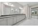 Bathroom featuring dual sink vanity with quartz countertops, marble floors, and glass shower at 14846 Contenta Loop, Bradenton, FL 34211