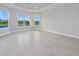 Bright bedroom featuring tray ceiling, wood-look tile flooring and windows with picturesque views at 14846 Contenta Loop, Bradenton, FL 34211