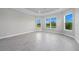 Bedroom featuring tray ceiling, wood-look tile flooring, and large windows with picturesque views at 14846 Contenta Loop, Bradenton, FL 34211