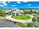 Stunning aerial view of clubhouse featuring a circular drive, well-manicured landscaping, and a lakeside view at 14846 Contenta Loop, Bradenton, FL 34211