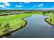 Aerial view of a scenic golf course with a pond and residential area under a blue sky with clouds at 14846 Contenta Loop, Bradenton, FL 34211
