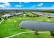 Scenic aerial shot of a golf course with a pond and surrounding community under a partly cloudy sky at 14846 Contenta Loop, Bradenton, FL 34211