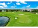 Golf course view with lush green grass, water feature, sand traps, and clubhouse, under a blue sky with white clouds at 14846 Contenta Loop, Bradenton, FL 34211