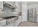 Modern kitchen with stainless steel appliances, gray subway tile backsplash, and light gray cabinets at 14846 Contenta Loop, Bradenton, FL 34211
