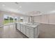 Modern eat-in kitchen island with marble countertops, stainless beverage cooler, and backyard view at 14846 Contenta Loop, Bradenton, FL 34211