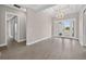 Spacious living room featuring wood-look flooring, elegant lighting, and access to the front yard at 14846 Contenta Loop, Bradenton, FL 34211