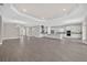 Spacious living room featuring an open floor plan, modern kitchen with island, and elegant gray wood floors at 14846 Contenta Loop, Bradenton, FL 34211