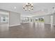Expansive living room featuring wood-look floors, elegant lighting, and access to an open kitchen at 14846 Contenta Loop, Bradenton, FL 34211