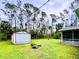 Large backyard with a shed, screened in patio, and stump seating at 15090 Rebecca Ave, Port Charlotte, FL 33953