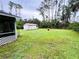 Spacious backyard with a shed, surrounded by lush grass and trees at 15090 Rebecca Ave, Port Charlotte, FL 33953