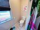 Bright bathroom with flamingo decor and window with blinds at 15090 Rebecca Ave, Port Charlotte, FL 33953