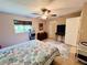 Bright bedroom features a ceiling fan, window with blinds, and an ocean-themed comforter at 15090 Rebecca Ave, Port Charlotte, FL 33953