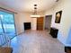 An open dining room with tile floors, a fireplace, a modern light fixture and glass sliding doors at 15090 Rebecca Ave, Port Charlotte, FL 33953