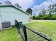 Side exterior of the house with a fenced-in yard and well-manicured lawn at 15090 Rebecca Ave, Port Charlotte, FL 33953