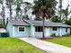 Inviting single-story home with a well-manicured lawn and a long concrete driveway leading to the entrance at 15090 Rebecca Ave, Port Charlotte, FL 33953