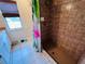 Shower with brown tiles and flamingo-themed shower curtain in bright bathroom at 15090 Rebecca Ave, Port Charlotte, FL 33953