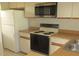 Functional kitchen with white appliances and wood-style countertops at 429 Cerromar Ln # 353, Venice, FL 34293