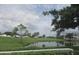 Tranquil view of a pond and golf course seen through a screened window, offering serenity at 429 Cerromar Ln # 353, Venice, FL 34293