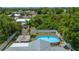 Angle aerial shot displays backyard with pool, deck, mature trees, and fenced yard at 732 Haleybury St, Port Charlotte, FL 33948
