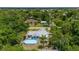 Close aerial view of home with metal roof and above ground pool surrounded by tropical foliage at 732 Haleybury St, Port Charlotte, FL 33948