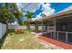 View of the backyard featuring a swing, pergola, screened patio, and lush landscaping at 732 Haleybury St, Port Charlotte, FL 33948