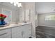 Bright bathroom featuring a vanity with a modern sink, mirror, and gray wood-look floors at 732 Haleybury St, Port Charlotte, FL 33948
