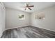 Cozy bedroom with two windows, wood-look floors, and a ceiling fan at 732 Haleybury St, Port Charlotte, FL 33948
