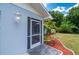 Close-up of the home's exterior with decorative landscaping, freshly painted and screened entry at 732 Haleybury St, Port Charlotte, FL 33948