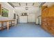 Well-lit garage with painted floor, workbench, storage cabinets and water heater at 732 Haleybury St, Port Charlotte, FL 33948