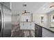 Open kitchen layout with stainless steel refrigerator, center island, and access to other rooms at 732 Haleybury St, Port Charlotte, FL 33948