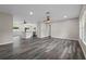 Open-concept living space with ceiling fans and wood-look flooring, adjacent to the kitchen at 732 Haleybury St, Port Charlotte, FL 33948