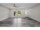 Spacious living area with wood-look flooring, flooded with natural light, showing the entrance at 732 Haleybury St, Port Charlotte, FL 33948